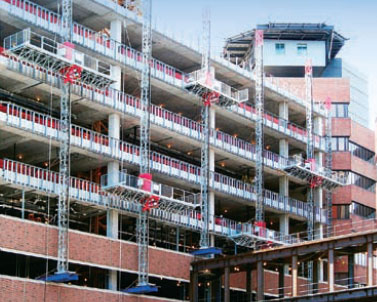 Mast climbers resting on cantilevered platforms extend from this building.