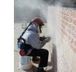 image of construction worker tuckpointing a brick wall